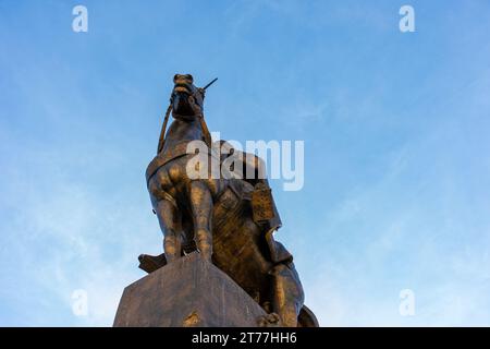 Low-angle view of Emir Abdelkader's statue against a blue sky in Algiers City. Stock Photo