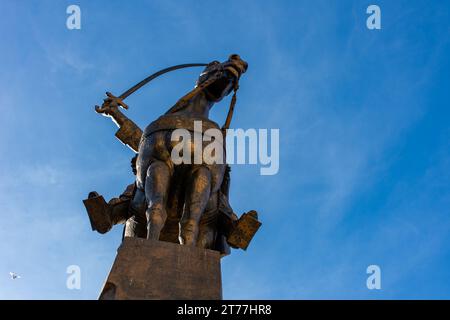 Low-angle view of Emir Abdelkader's statue against a blue sky in Algiers City. Stock Photo