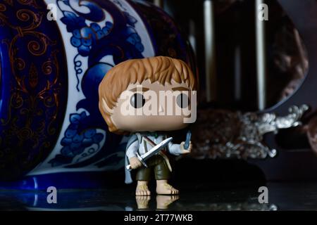 Funko Pop action figure of hobbit Sam from fantasy movie The Lord of the Rings. Dark palace, ancient columns, porcelain blue keg with patterns. Stock Photo