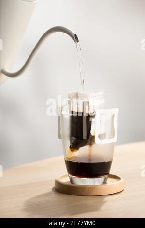 The hot water is poured over the roasted and ground coffee, in a filter paper ready to use. Stock Photo