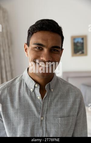 Portrait of happy biracial man standing in bedroom at home Stock Photo