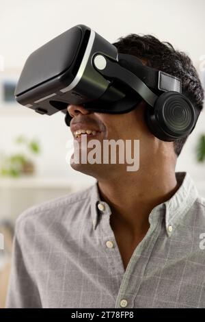 Happy biracial man using vr headset at home Stock Photo