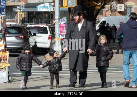 A Hasidic jewish father walks hand in hand with his son and 2 daughters. On Bedford Avenue in Williamsburg, Brooklyn, New York. Stock Photo