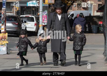 A Hasidic jewish father walks hand in hand with his son and 2 daughters. On Bedford Avenue in Williamsburg, Brooklyn, New York. Stock Photo