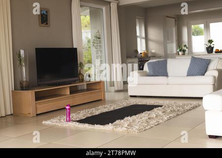 Close up of yoga mat and bottle of water on floor at home Stock Photo