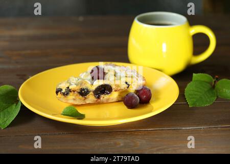 Delicious Quiche pie with cherry filling on yellow plate with cup of coffe Stock Photo