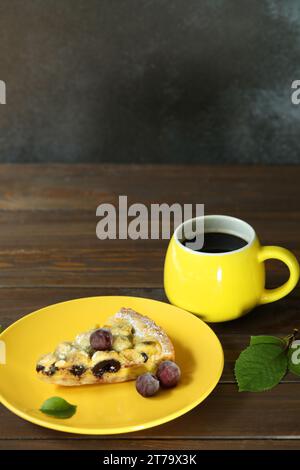 Delicious Quiche pie with cherry filling on yellow plate with cup of coffe Stock Photo