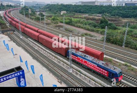 (231114) -- YONGCHUAN, Nov. 14, 2023 (Xinhua) -- This aerial photo taken on Nov. 14, 2023 shows a JSQ freight train departing at Langantan Station in Yongchuan District of southwest China's Chongqing. The first JSQ freight train from Yongchuan District of southwest China's Chongqing directly to Europe departed on Tuesday. The train is loaded with 232 vehicles manufactured by Great Wall Motors in Yongchuan, with a total value of about 42 million yuan (about 5.76 million U.S. dollars). (Xinhua/Wang Quanchao) Stock Photo