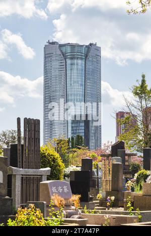 Tokyo, Japan - April 08, 2023: View of Roppongi Hills Mori Tower over Aoyama Cemetery. It is a 238 meter high skyscraper, built in 2000 - 2003 Stock Photo
