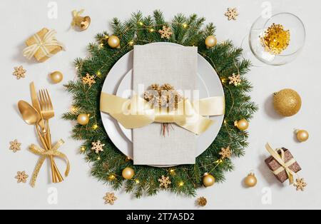 Golden Christmas table setting on a white background. New Year serving. Christmas dinner. Top view, flat lay. Stock Photo
