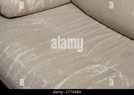 Defects on a white leather sofa. Damaged to leather furniture. Stock Photo