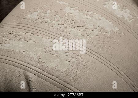 Defects on a white leather sofa. Damaged to leather furniture. Stock Photo