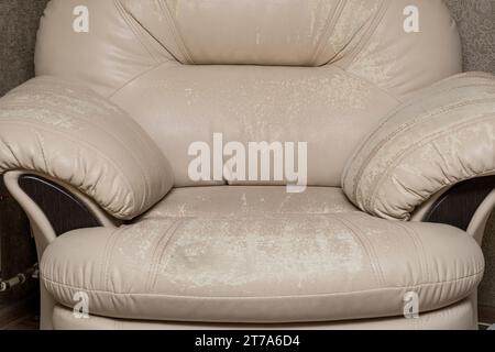 Defects on a white leather sofa. Damaged to leather furniture. Stock Photo