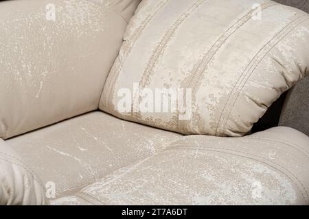 Defects on a white leather sofa. Damaged to leather furniture. Stock Photo