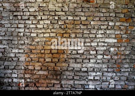 A brick wall with varying colors and textures, ranging from white to black. Stock Photo