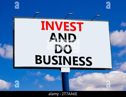Invest and do business symbol. Concept word Invest and do business on beautiful big white billboard. Beautiful blue sky cloud background. Invest and d Stock Photo