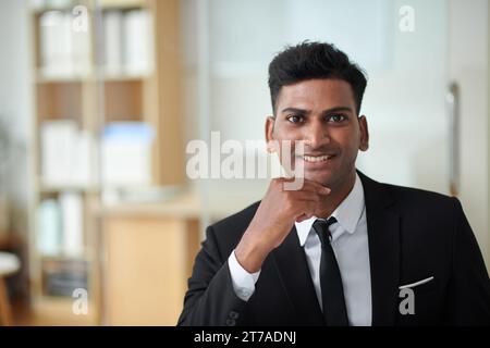 Portrait of cheerful young entrepreneur in formal suit working in office Stock Photo