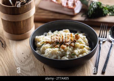 Halusky as traditional Slovak potato gnocchi with sheep cheese bryndza, fried bacon and chives. Stock Photo