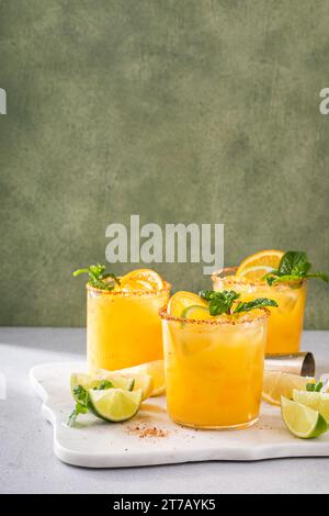 Orange and lime margarita with chili on rim, spicy refreshing tropical margarita cocktail Stock Photo
