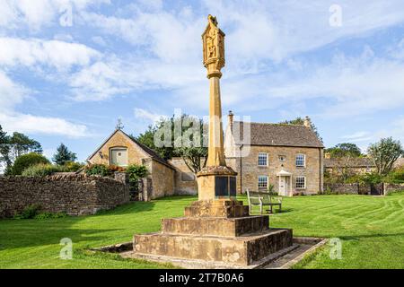 The war memorial and Civic Trust House on the green in the Cotswold village of Guiting Power, Gloucestershire, England UK Stock Photo