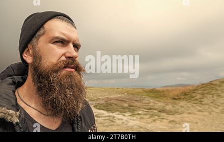 photo of caucasian man in the mountain, copy space banner. caucasian man outdoor. caucasian man has beard. caucasian man having moustache. Stock Photo