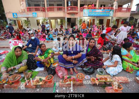 Hindu devotees sit together on the floor of Loknath Temple to observe the Rakher Upobash festival to honor Baba Lokenath, an 18th Century Hindu saint Stock Photo