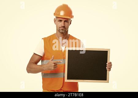 worker show advertisement pointing finger on background. photo of worker show advertisement holding blackboard. worker show advertisement isolated on Stock Photo