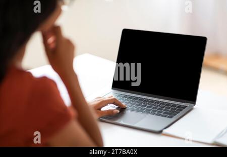 Over shoulder shot of unrecognizable businesswoman working on laptop Stock Photo