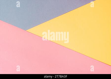Yellow, pink and blue colored paper. Geometric empty paper background of three tones for copy space. Stock Photo