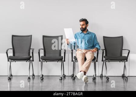 Indian man analyzing document in job interview waiting room Stock Photo