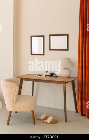 Two empty picture frames hanging over a desk in a stylish modern living room Stock Photo