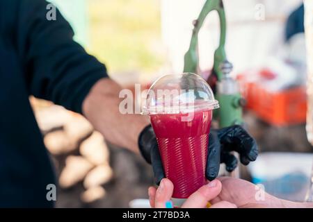a man cutting a pomelo fruit on a board and making juice at the market, bazaar Stock Photo