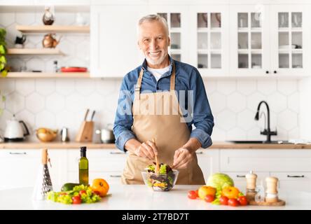 Portrait Of Handsome Mature Chef Man In Apron Posing In Kitchen Interior Stock Photo