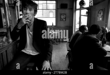 Legendary Irish rockstar, singer/songwriter & frontman for The Pogues & The Popes, Shane MacGowan pictured drinking and smoking at his favourite London pub Filthy MacNasty’s , Islington 1994 Stock Photo