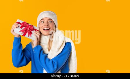 Happy woman holding a gift box with joy Stock Photo