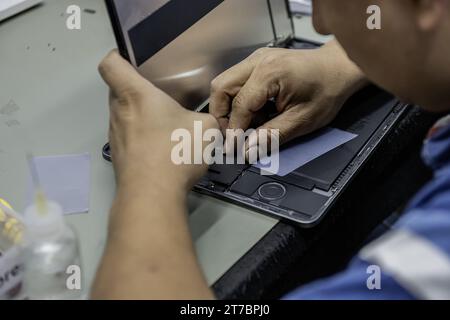 A technician repairing the inside of a tablet pro Stock Photo