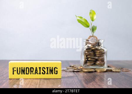 Question concept. On the table are cubes with questions and a red plaque with the inscription - Fundraising. Stock Photo