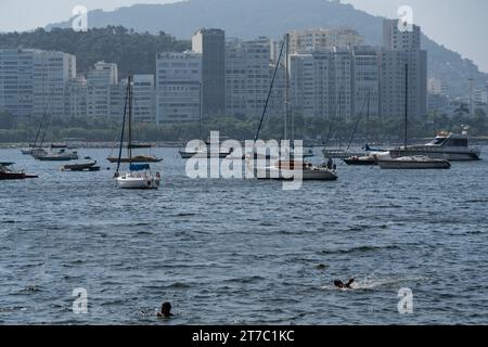 Rio De Janeiro, Brazil. 14th Nov, 2023. Men swim in the sea near the Urca beach in Rio de Janeiro, Brazil, Nov. 14, 2023. Credit: Wang Tiancong/Xinhua/Alamy Live News Stock Photo