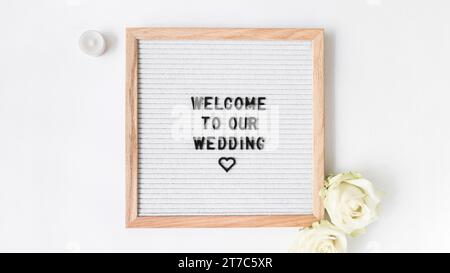 Candle rose with welcome frame wedding white backdrop Stock Photo