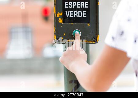 Human hand pressing green wait signal Stock Photo