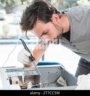 Side view male technician repairing computer cpu workshop Stock Photo