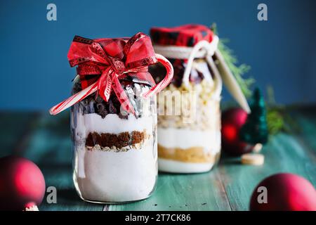 Variety of gifts of chocolate chip cookie dough and macadamia nut recipe mixture of ingredients for baking cookies for Christmas.  Tied with a red bow Stock Photo