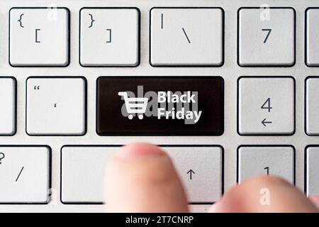 Black friday text and shopping cart on keyboard. Black friday concept. black button on the keyboard of modern ultrabook. caption on the button. Stock Photo