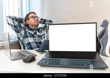 handsome man feeling bored, frustrated and sleepy after a tiresome. businessman and desk concept. copy space on an empty white laptop screen. a happy Stock Photo