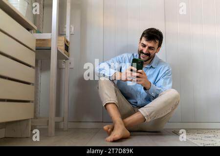 Young man happy to exchange messages with friends uses free internet connection on electronic gadget Stock Photo
