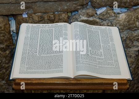 A Talmud open to the text from the tractate Ketubot rests on a prayer stand in front of the Western Wall in Jerusalem. Stock Photo