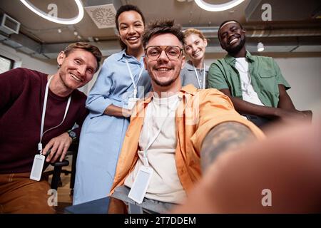 Selfie portrait of businessman smiling at camera together with his colleagues Stock Photo