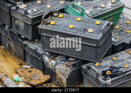 Battery waste. Pile of old used EV car batteries toxic waste chemicals lead leak impact nature no recycled. Stock Photo