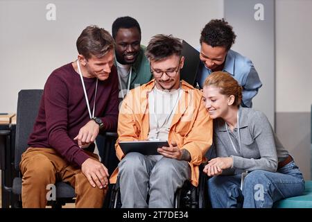 Businessman with disability working on tablet pc together with his colleagues Stock Photo
