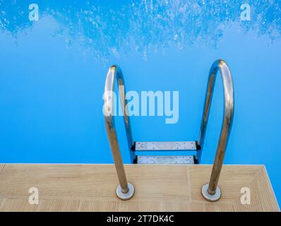 A set of metal steps into the blue water of a swimming pool at the Destino hotel, Sidari, Corfu, Greece Stock Photo